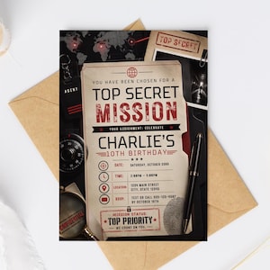 May include: A rectangular invitation card with a spy theme featuring the text TOP SECRET MISSION and CHARLIE'S 10TH BIRTHDAY. The design includes a world map, a magnifying glass, a combination lock, and a black pen on a dark background.