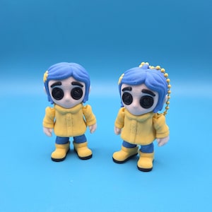 May include: Two small figurines featuring a character with blue hair, black button eyes, a yellow raincoat, and yellow boots. One figurine stands independently, while the other includes a yellow ball chain attached to the top of its head.