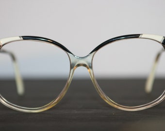 May include: Clear plastic eyeglasses with black and white accents on the frame.