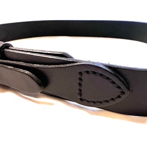 K&ouml;nnte beinhalten: Nahaufnahme eines schwarzen Lederg&uuml;rtels mit einem gen&auml;hten Design. Der G&uuml;rtel besteht aus einem einzigen Lederst&uuml;ck und hat ein klassisches, minimalistisches Design. Die Schnalle ist auf dem Bild nicht zu sehen.