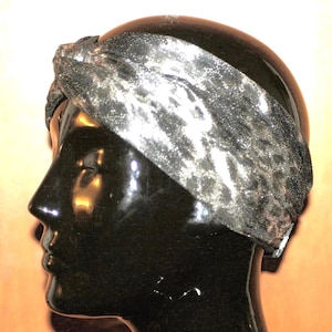 May include: A black and silver patterned headband with a knotted design.