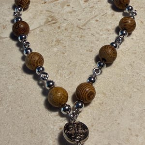 Olive wood bead car rosary with magnetic clasp, looped wire connectors and pink pater bead and metal crucifix.