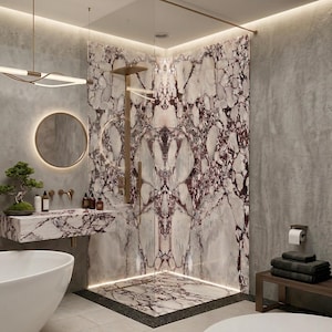 May include: A luxurious bathroom with a marble shower and sink. The marble features a white and burgundy pattern. A round mirror with a gold frame hangs above the sink. A white bathtub is in the foreground.