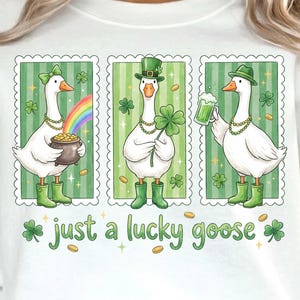 May include: White sweatshirt with a St. Patrick's Day design. Three cartoon geese are in green frames, each with a different theme. One holds a pot of gold, another a four-leaf clover, and the last a green beer. The text reads "just a lucky goose".