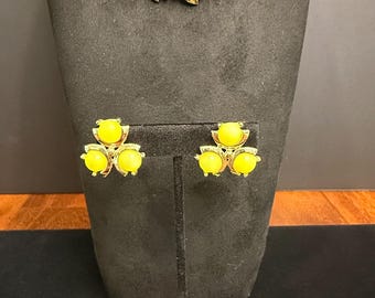 May include: A vintage jewelry set featuring a necklace, earrings, and bracelet. The set has bright yellow cabochon stones set in silver-tone metal. The necklace and bracelet have a repeating pattern of the yellow stones.