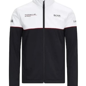 May include: A black, white, and burgundy zip-up jacket with the "PORSCHE MOTORSPORT" and "BOSS" logos. The jacket has a high collar and a color-blocked design, with white at the top, a burgundy stripe, and black at the bottom. The jacket has long sleeves.