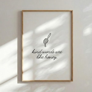 Peut inclure: Une affiche encadrée avec un fond clair et une illustration de cuillère à miel. Le texte "kind words are like honey" est écrit en cursive en dessous de l'illustration. Le cadre est de couleur marron clair.