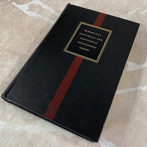May include: A hardcover book with a black cover and a red stripe down the spine. The book has gold lettering and the text "McGraw-Hill Electrical and Electronic Engineering Series".