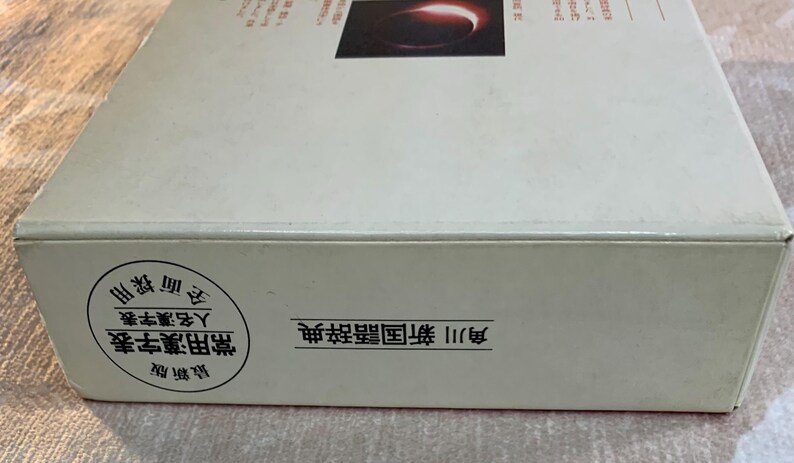 May include: A white box with Japanese text and a circular seal. The box has a dark image on the top and text on the side. The seal contains Japanese text. The box appears to be a dictionary.