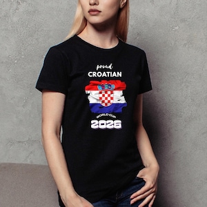 May include: Black t-shirt featuring the Croatian flag design with the words "proud Croatian" and "World Cup 2026" in white. The flag design includes red, white, and blue colors. The shirt is a crew neck style.