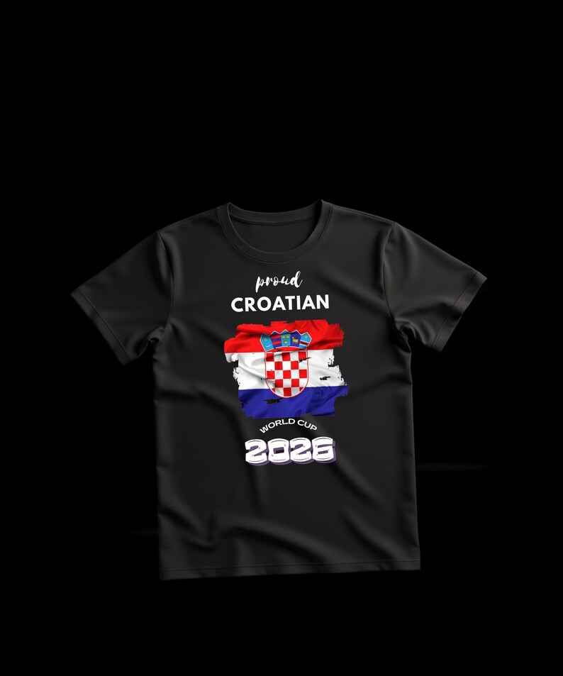 May include: Black t-shirt with the text "proud CROATIAN" above a graphic of the Croatian flag. Below the flag is "WORLD CUP 2026" in white text. The shirt has a crew neck and short sleeves.