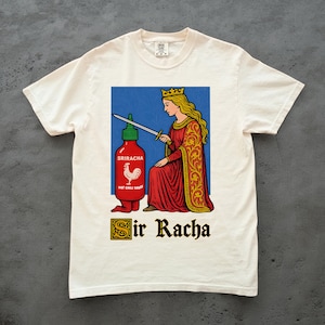 May include: White t-shirt featuring a graphic of a Sriracha hot sauce bottle and a queen holding a sword. The queen is wearing a red dress and gold crown. The text "Sir Racha" is below the graphic.