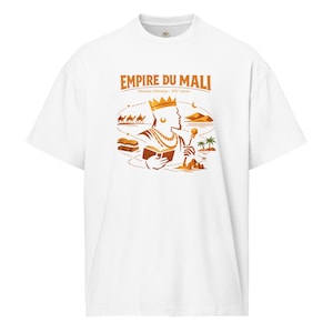 May include: White t-shirt featuring a graphic design in shades of orange and brown. The design includes the text "EMPIRE DU MALI" and an illustration of a figure with a crown, holding a book and scepter, with camels and desert scenery.