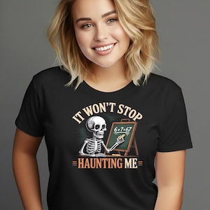 Peut inclure: T-shirt noir avec un squelette enseignant les mathématiques sur un tableau noir. Le texte sur le t-shirt dit "IT WON'T STOP HAUNTING ME". Le tableau noir affiche l'équation "6 x 7 = 67".