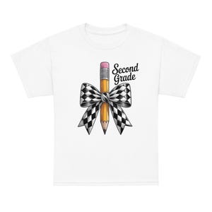 Peut inclure: Un t-shirt blanc avec un motif représentant un crayon jaune à gomme rose, noué d'un grand nœud à carreaux noirs et blancs. Le texte "Second Grade" est imprimé en police cursive noire sur la droite du motif du crayon et du nœud.