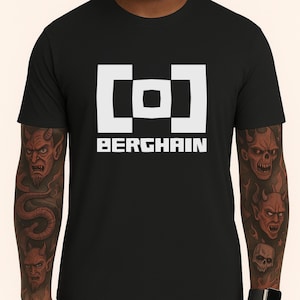 May include: Black t-shirt with a white geometric design and the word "BERGHAIN" in a bold, sans-serif font. The design is centered on the chest. The shirt is a classic crew neck style.