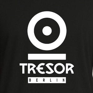 Könnte beinhalten: Schwarzes T-Shirt mit weißer Grafik. Die Grafik zeigt einen großen weißen Kreis mit einem kleineren weißen Kreis darin, über einer horizontalen weißen Linie. Darunter steht das Wort "TRESOR" und darunter "BERLIN" in einem weißen Rechteck.