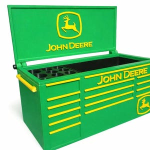 May include: Green toolbox with yellow accents and the John Deere logo. The toolbox has an open lid, a compartment for tools, and the John Deere name on the side. The toolbox is designed to store tools and equipment.