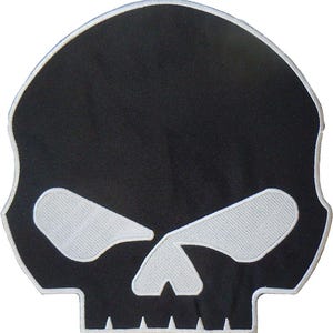 May include: A black skull patch with white embroidered details. The skull has white eyes and a white outline. The patch is a fabric applique, suitable for sewing or ironing onto clothing or accessories.