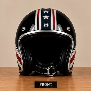 May include: A black open-face motorcycle helmet featuring a central vertical stripe with white stars on a blue background, flanked by red and white stripes. The helmet has a silver trim, chrome snaps, and a black chin strap with a metal D-ring closure.