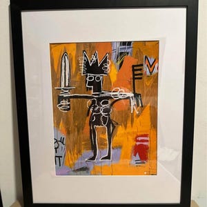 May include: Abstract art print in a black frame. The artwork features a black figure with a crown, holding a sword and a key, set against an orange and yellow background. The style is reminiscent of Basquiat.