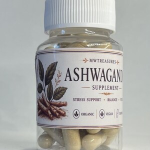 May include: A clear plastic bottle with a white lid filled with beige capsules. The label reads "ASHWAGANDHA SUPPLEMENT" with illustrations of leaves and roots. The label also states "Stress Support, Balance, Organic, Vegan".