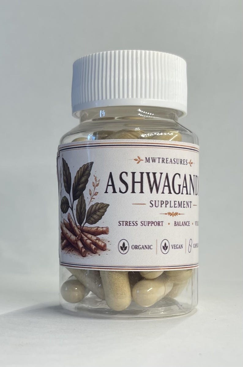 May include: A clear plastic bottle with a white lid filled with beige capsules. The label reads "ASHWAGANDHA SUPPLEMENT" with illustrations of leaves and roots. The label also states "Stress Support, Balance, Organic, Vegan".