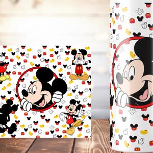 K&ouml;nnte beinhalten: Wei&szlig;er Becher und Untersetzer mit einem sich wiederholenden Muster aus roten, gelben und schwarzen Mickey Mouse-K&ouml;pfen. Der Becher und der Untersetzer haben eine gro&szlig;e Mickey Mouse-Grafik in einem roten Kreis.