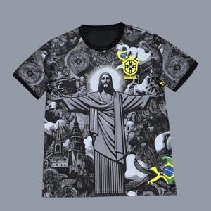 May include: Black and gray t-shirt featuring a detailed illustration of Christ the Redeemer with outstretched arms. The shirt has a black collar and sleeves, and includes the Brazilian flag and the word "Brasil".