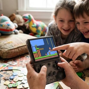 May include: A handheld video game console with a screen displaying a classic platformer game. The console is black with buttons and a directional pad. Children are smiling and pointing at the screen, surrounded by toys.