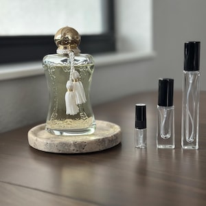 May include: A white ceramic mug with a black handle and the text "But First, Coffee" in a black, bold font. The mug is on a white surface. The mug is approximately 4 inches tall.