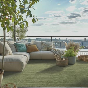 May include: An outdoor living space featuring a large, off-white sectional sofa with several throw pillows in shades of green and brown. A green rug covers the floor. The scene is set on a balcony overlooking a city and water.