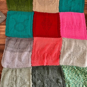 May include: A knitted patchwork blanket with squares in various colours, including green, teal, red, pink, grey, and beige. Each square features a different knitted design.