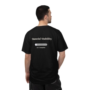 May include: Black t-shirt with the text "Financial Stability" above a progress bar showing 12% complete. The shirt is a short-sleeved crew neck style.