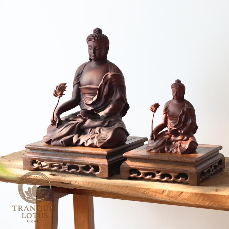 Two Shakyamuni Buddha statues placed on Square Small 6.3 inch (16cm) and Square High 7.9 inch (20cm) wooden display stands. Side-by-side comparison showing the size difference between two square altar risers.