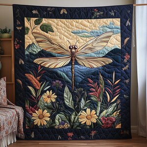 Peut inclure: Une grande tenture murale matelassée avec un motif de libellule détaillé. L'œuvre d'art présente une libellule avec des motifs d'ailes complexes, sur fond de montagnes, de ciel et d'éléments floraux. La palette de couleurs comprend des bleus, des verts et des jaunes.