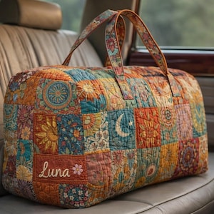 May include: A quilted duffel bag with a patchwork design in shades of orange, blue, and teal. The bag features floral and celestial patterns, with the name "Luna" embroidered on the side. The handles are patterned with floral designs.