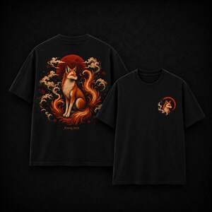 Puede incluir: Una camiseta negra de manga corta con un gr&aacute;fico grande en la espalda de un zorro sentado ante una luna roja con nubes arremolinadas y el texto Kitsune Spirit. La parte delantera de la camiseta muestra una versi&oacute;n m&aacute;s peque&ntilde;a del gr&aacute;fico.
