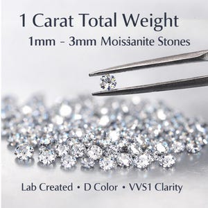 May include: Close-up of multiple sparkling moissanite stones. One stone is held by tweezers, with the text "1 Carat Total Weight" and "1mm - 3mm Moissanite Stones" at the top. The text "Lab Created • D Color • VVS1 Clarity" is at the bottom.