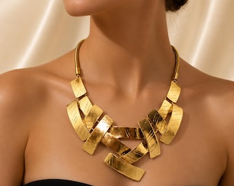 Colar babador dourado, estilo moderno europeu, com textura geométrica.