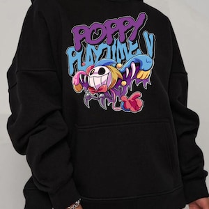 May include: Black hooded sweatshirt featuring a colorful graphic from "Poppy Playtime". The design includes the text "Poppy Playtime" in purple and blue, along with a cartoon character with a smiling face and colorful details.
