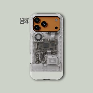 May include: A clear phone case featuring a visible internal circuit board design, a small cooling fan, and a prominent orange camera module. The text SYSTEM 84 is printed in the upper left corner. The case has a white base and a transparent back.