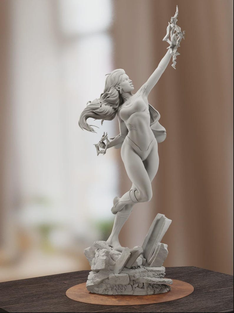 K&ouml;nnte beinhalten: Eine graue Skulptur einer Frau in dynamischer Pose, die eine stilisierte Flamme &uuml;ber ihrem Kopf h&auml;lt. Die Figur ist in einem figurbetonten Outfit mit flie&szlig;endem Haar und einem Umhang gekleidet. Die Skulptur ist auf einem felsigen Sockel montiert.