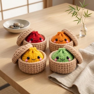 Può includere: Quattro ravioli di peluche all'uncinetto in cestini color marrone chiaro con coperchi. Ogni raviolo ha una forma rotonda, un viso sorridente con occhi a perla neri, guance rosa e un colore distinto: rosso, arancione, giallo e verde.