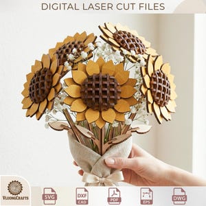 Könnte beinhalten: Ein hölzernes Sonnenblumenbouquet mit lasergeschnittenen Details, mit gelben Blütenblättern und braunen Zentren. Das Bouquet wird in einer beigefarbenen Stoffverpackung mit einer Schleife gehalten. Der Text "DIGITAL LASER CUT FILES" steht oben.