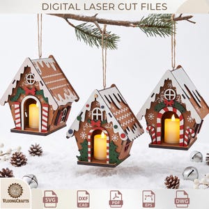 Pode incluir: Três ornamentos suspensos de casas de gengibre feitos de madeira, com detalhes de glacê branco, detalhes de bengalas doces vermelhas e brancas e acabamentos verdes. Cada casa contém uma pequena vela LED amarela brilhante.