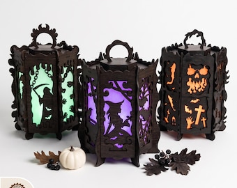 May include: Three dark brown laser-cut wooden lanterns with hexagonal shapes and handles. The panels feature cutouts of a grim reaper, a witch, and a skull, illuminated from within by green, purple, and orange lights. Text reads DIGITAL LASER CUT FILES.
