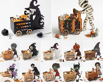 Könnte beinhalten: Digitale Lasercut-Dateien für Halloween-Holzwagen, die von verschiedenen Figuren wie einer Hexe, einer Mumie, einem Geist, einem Vampir und einem Kobold geschoben werden. Die Wagen sind mit Süßigkeiten und kleinen Dekorationen gefüllt.