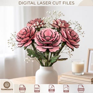 Op de afbeelding: Een boeket van roze houten bloemen met zwarte randen en groene bladeren in een witte vaas. Het arrangement bevat witte gipskruid. De afbeelding bevat de tekst "DIGITAL LASER CUT FILES".