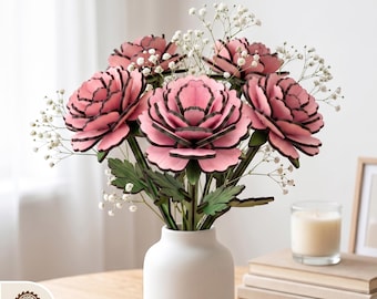 May include: A bouquet of pink wooden flowers with black edges and green leaves in a white vase. The arrangement includes white baby's breath. The image includes the text "DIGITAL LASER CUT FILES".
